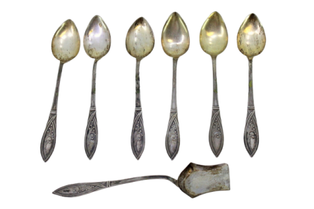 Conjunto de seis colheres de café e pá de açúcar em prata dourada nas conchas e relevos nos cabos.